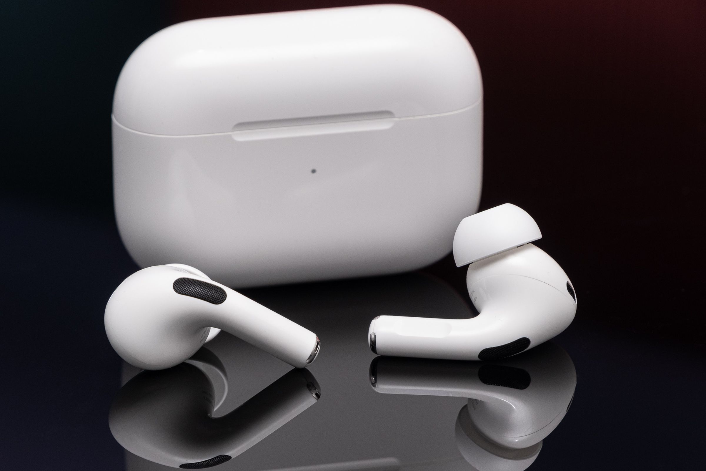 Apple’s second-generation AirPods Pro photographed on a reflective black surface.