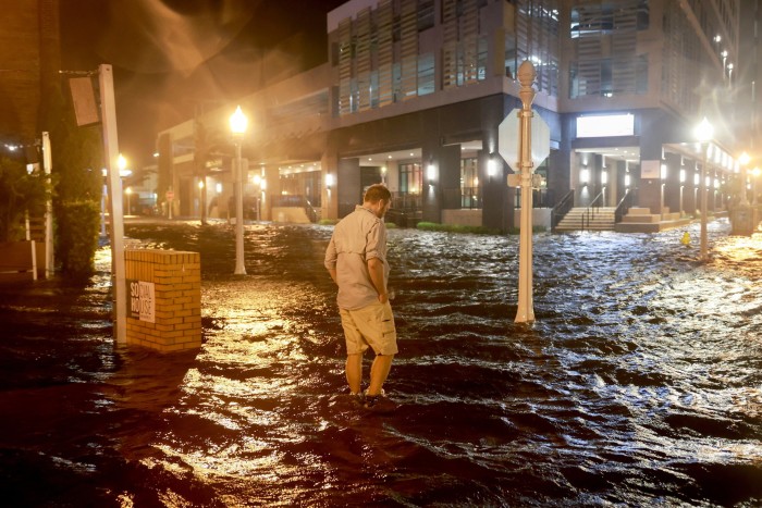 A man walks through flooded streets in Sarasota, Florida