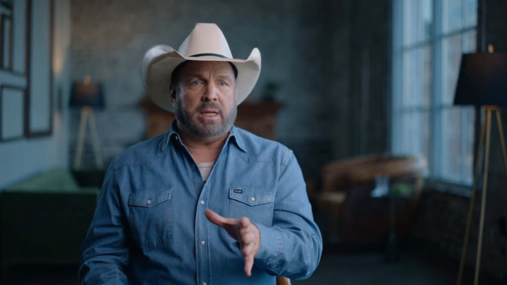 Garth Brooks speaks to the camera while wearing a hat.