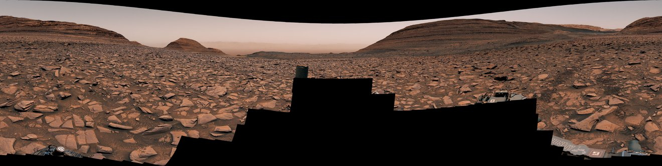 Curiosity's panoramic view heading west away from Gediz Vallis channel, showing tracks across rocky terrain. 