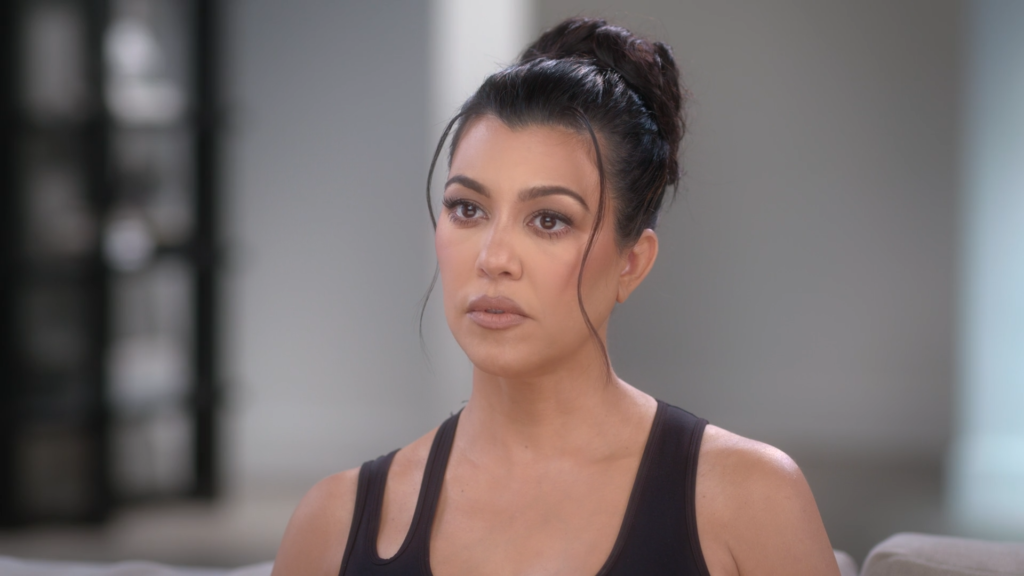 Kourtney Kardashian wears a serious face while speaking on The Kardashians to the confessional camera.