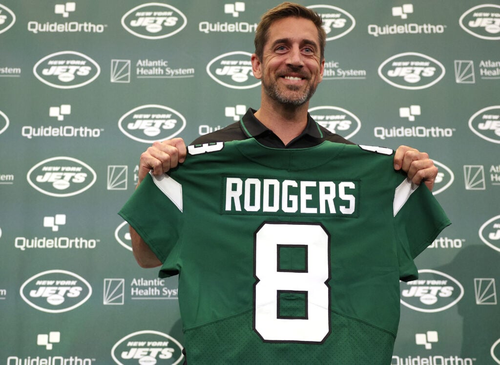 New York Jets quarterback Aaron Rodgers poses with a jersey during an introductory press conference at Atlantic Health Jets Training Center on April 26, 2023 in Florham Park, New Jersey.