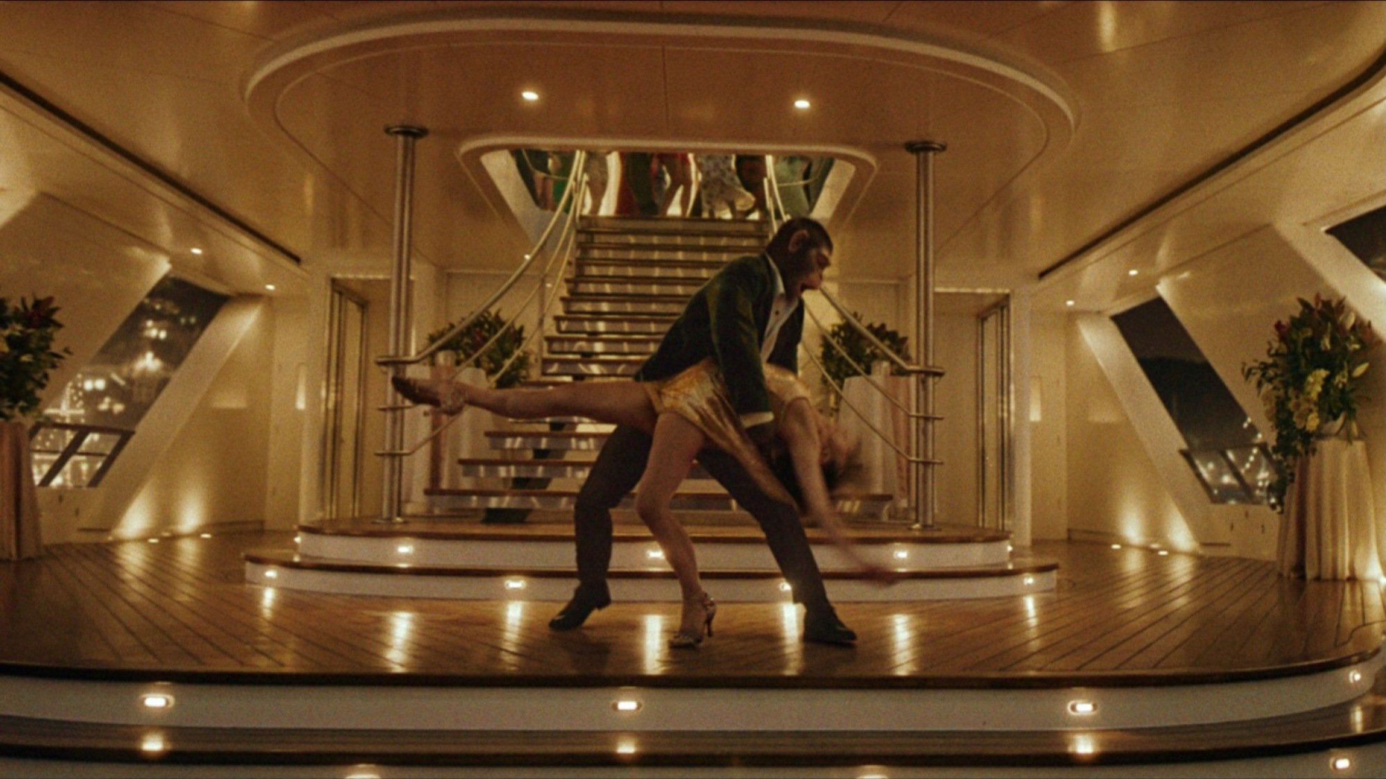 A chimp Robbie Williams (Jonno Davies) dances with Nicole Appleton (Raechelle Banno) in Better Man.