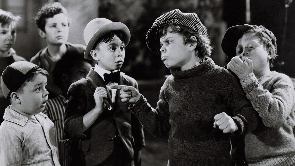 Carl Switzer in character as Alfalfa being bullied by another child in character as others look on.