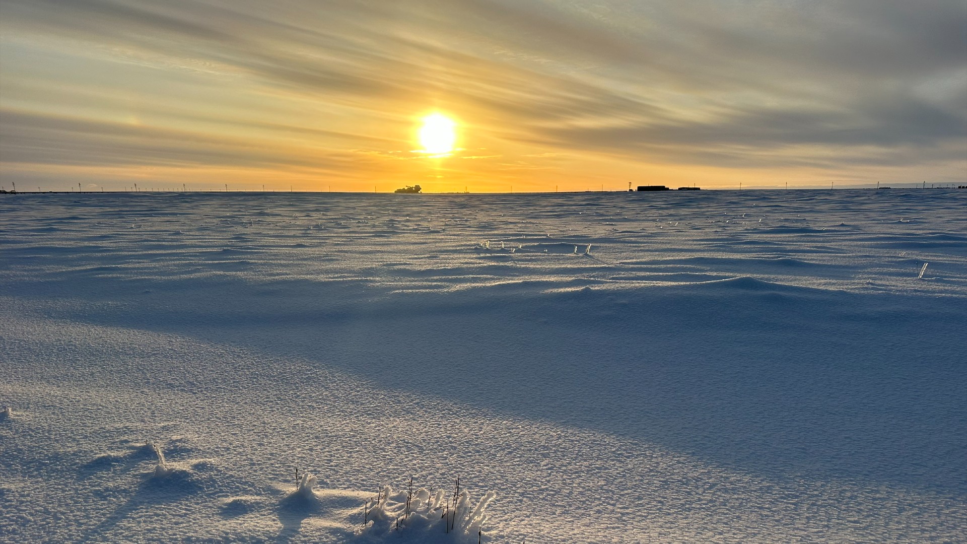 the sun shines on snowy permafrost