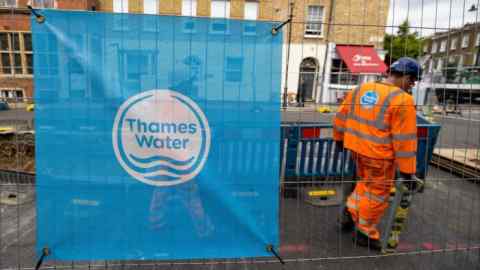 A sign displaying the Thames Water Ltd. company logo on protective barriers surrounding water supply works in London