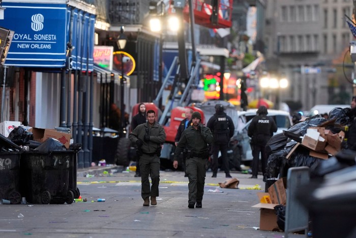 Emergency services personnel walk through debris on Canal and Bourbon Street in New Orleans.