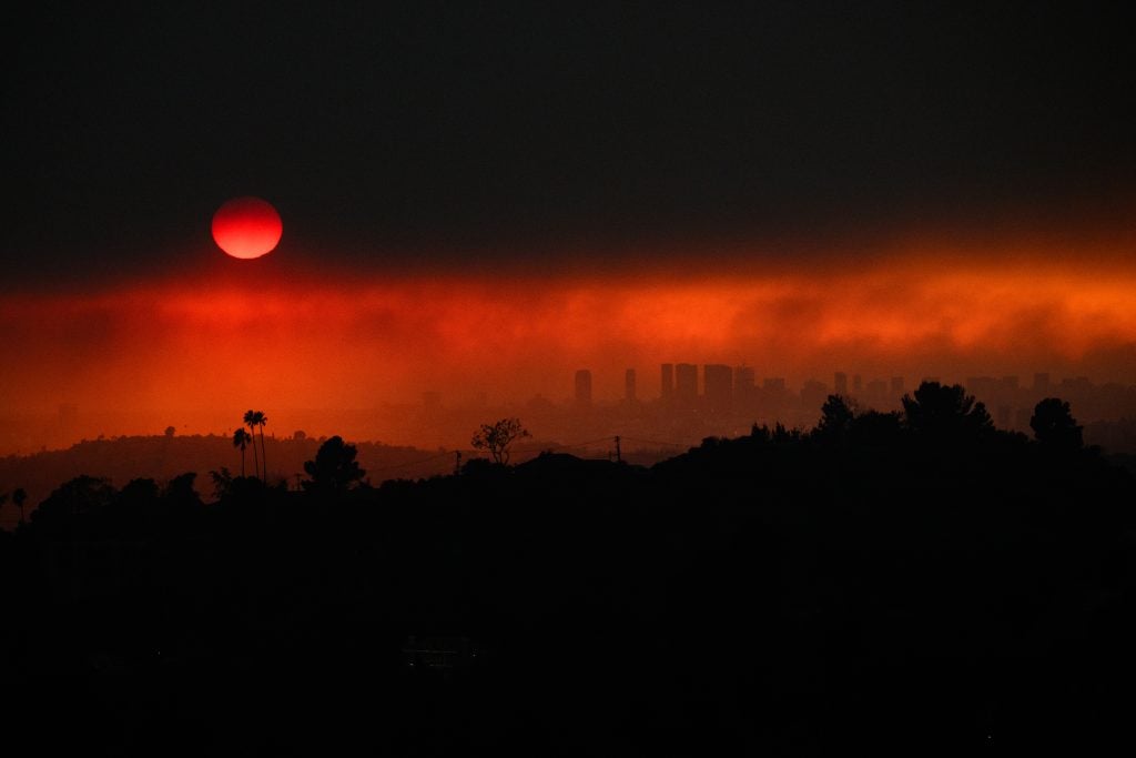 Smoke from the Los Angeles fires obscures the sun on January 8, 2025, creating a red horizon as if Dracula is attacking the city.