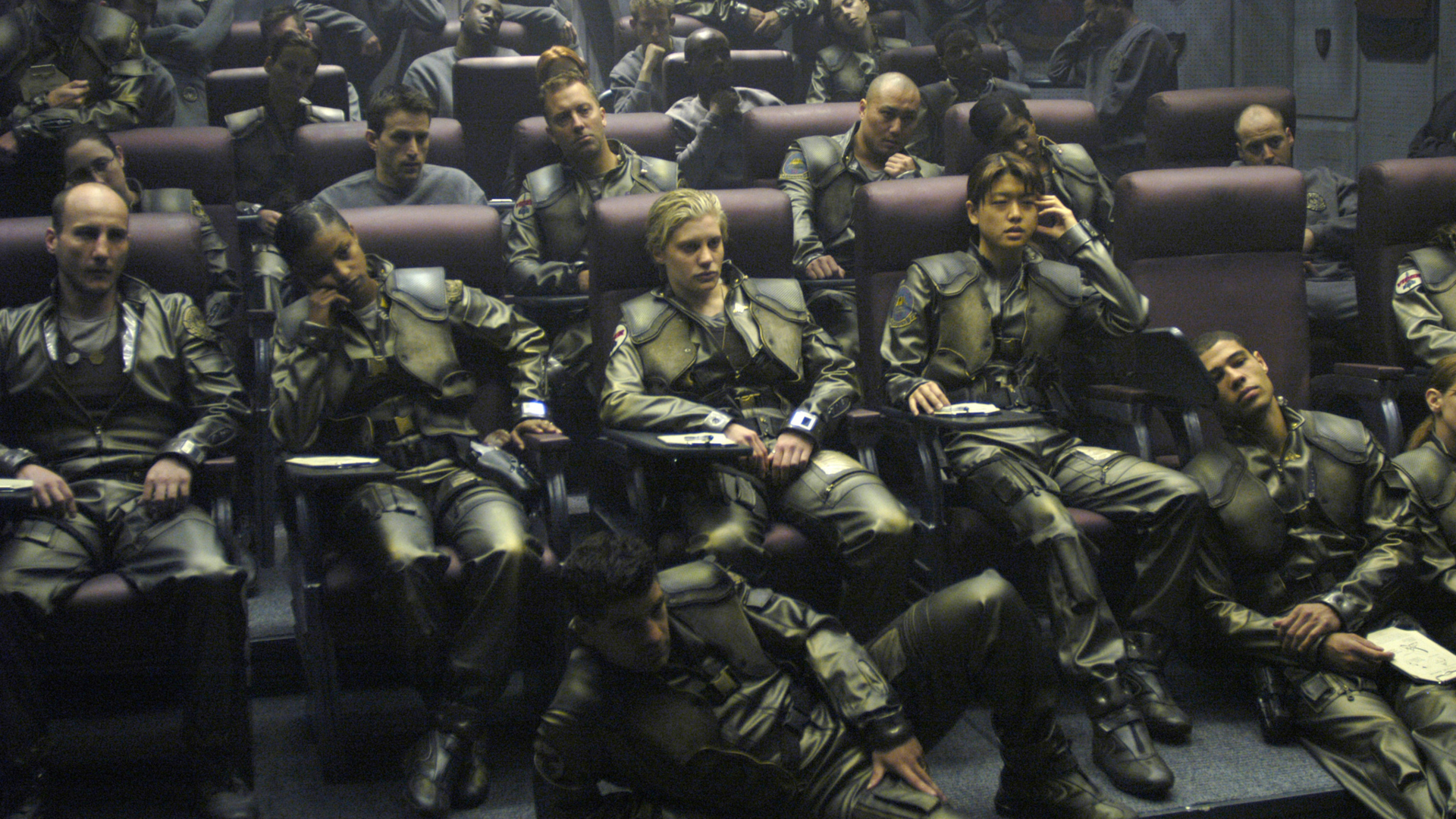 A group of pilots wearing green military fatigues sat in a briefing Battlestar Galactica (2004).