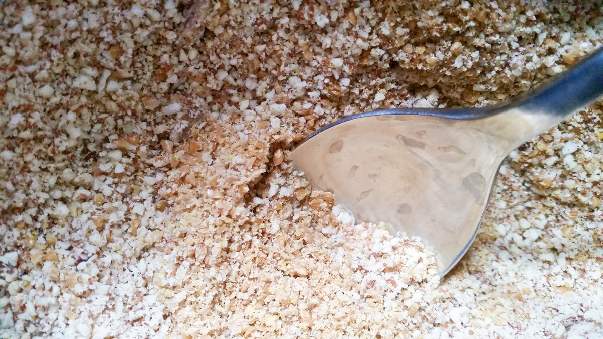 A spoon rests in milled flaxseed.