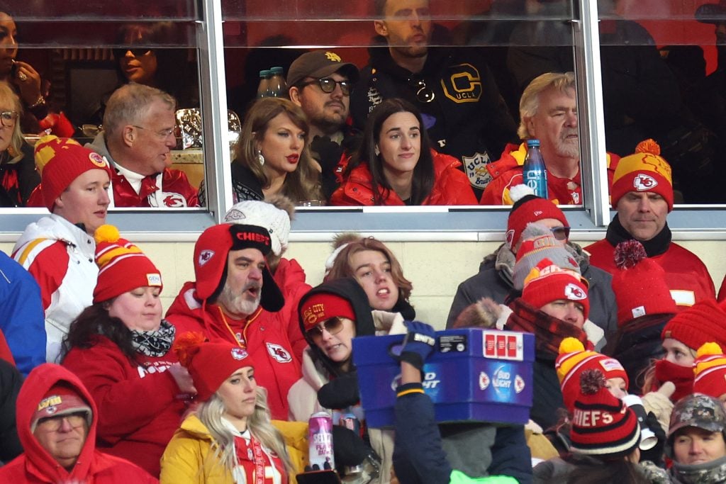 Singer-songwriter Taylor Swift talks with Caitlin Clark of the Indiana Fever during the second half in the AFC Divisional Playoff between the Houston Texans and the Kansas City Chiefs at GEHA Field at Arrowhead Stadium on January 18, 2025 in Kansas City, Missouri.