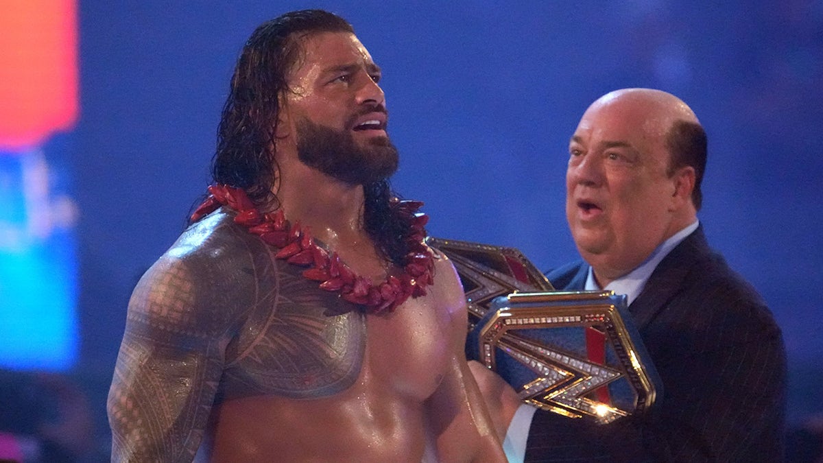 Paul Heyman walks with Roman Reigns