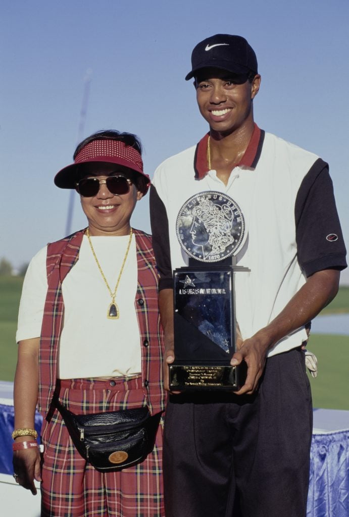 Tiger Woods of the United States celebrates with his mother Kultida Woods and the trophy after winning his first professional golf tournament at the PGA Las Vegas Invitational on 6th October 1996 at the TPC Summerlin Golf Course, Desert Inn, Las Vegas, Nevada.