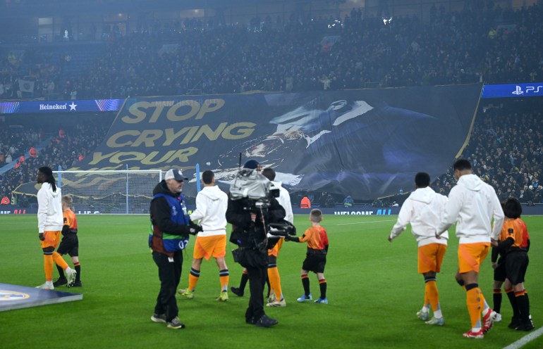 MANCHESTER, ENGLAND - FEBRUARY 11: Fans of Manchester City display a tifo which reads 'Stop crying your heart out' which includes a picture of Rodri of Manchester City kissing the Ballon d'or trophy prior to the UEFA Champions League 2024/25 League Knockout Play-off first leg match between Manchester City and Real Madrid C.F. at Manchester City Stadium on February 11, 2025 in Manchester, England. (Photo by Michael Regan/Getty Images)