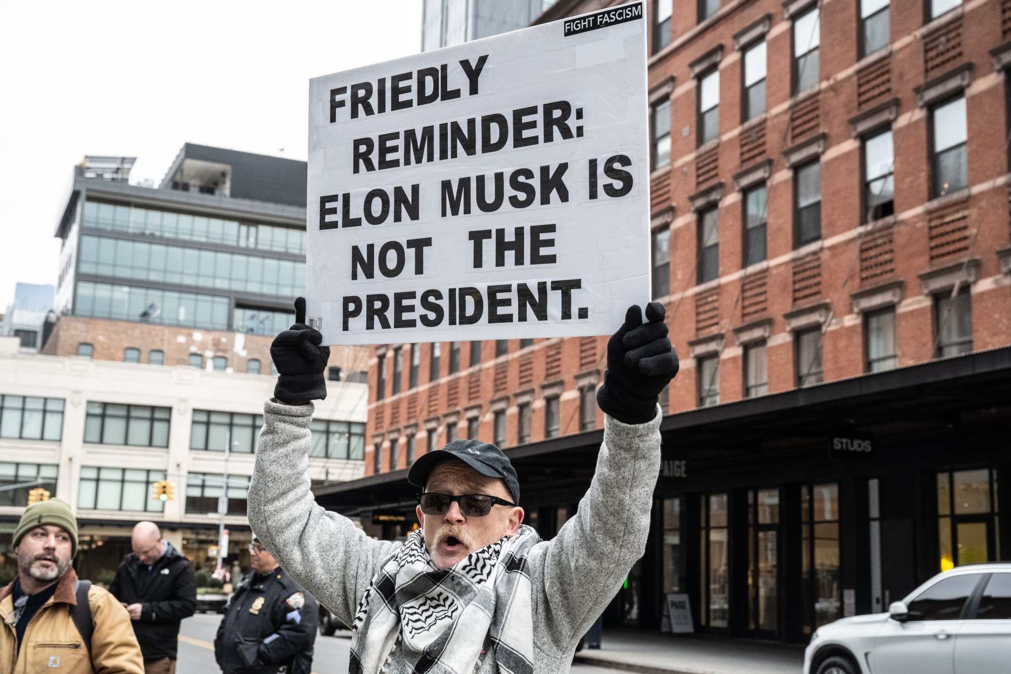 A protester holds a sign reading 