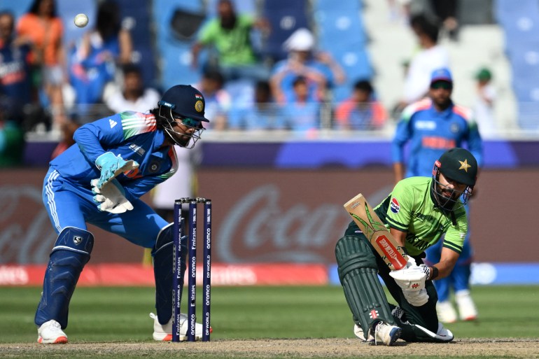 Pakistan's Saud Shakeel (R) plays a shot as India's wicketkeeper KL Rahul watches during the ICC Champions Trophy one-day international (ODI) cricket match between Pakistan and India at the Dubai International Stadium in Dubai on February 23, 2025. (Photo by Jewel SAMAD / AFP)