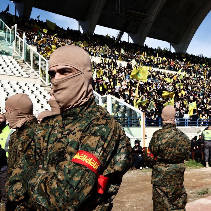 Hizbollah members stand on the day of a public funeral ceremony for late Hizbollah leaders Hassan Nasrallah and Hashem Safieddine in Camille Chamoun Sports City Stadium