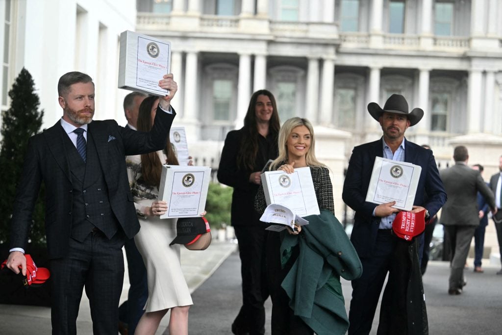 Political commentator Rogan O'Handley, aka DC Draino, TikToker Chaya Raichik, US conservative activist Scott Presler, commentator Liz Wheeler and US conservative political commentator Chad Prather carry binders bearing the seal of the US Justice Department reading "The Epstein Files: Phase 1" as they walk out of the West Wing of the White House in Washington, DC, on February 27, 2025. 