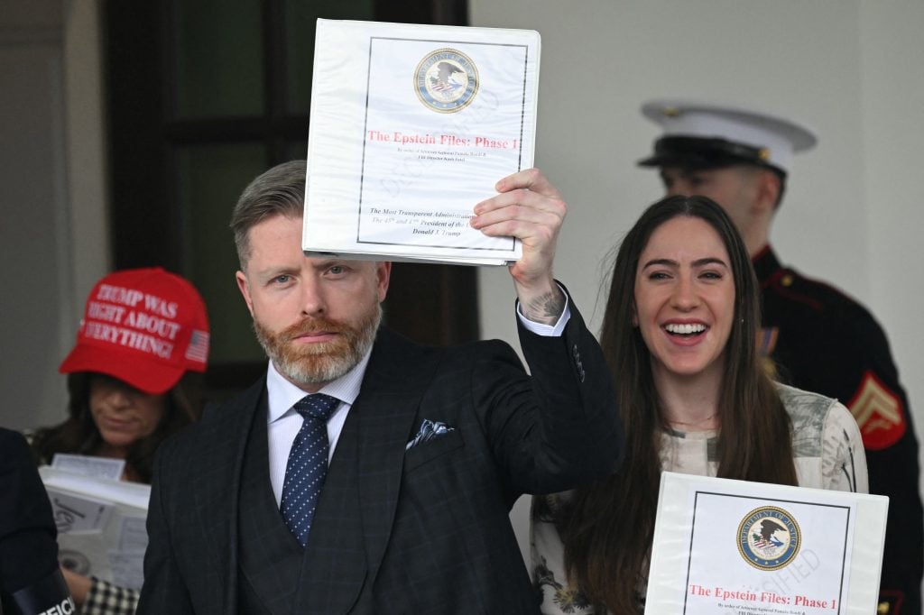 Political commentator Rogan O'Handley (C), aka DC Draino, US influencer Jessica Reed Kraus (L) and Chaya Raichik (R) carry binders bearing the seal of the US Justice Department reading "The Epstein Files: Phase 1" as they walk out of the West Wing of the White House in Washington, DC, on February 27, 2025.