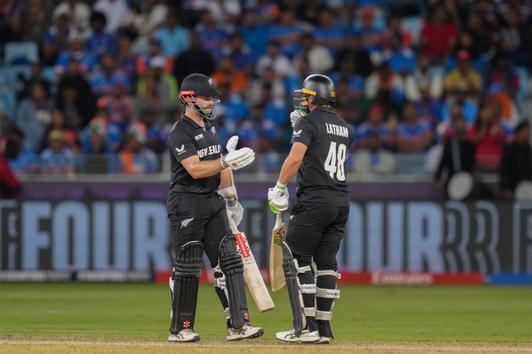 New Zealand's Kane Williamson, left, celebrates his fifty runs with his batting partner Tom Latham during the ICC Champions Trophy cricket match between India and New Zealand at Dubai International Cricket Stadium in Dubai, United Arab Emirates, Sunday, March 2, 2025. (AP Photo/Altaf Qadri )