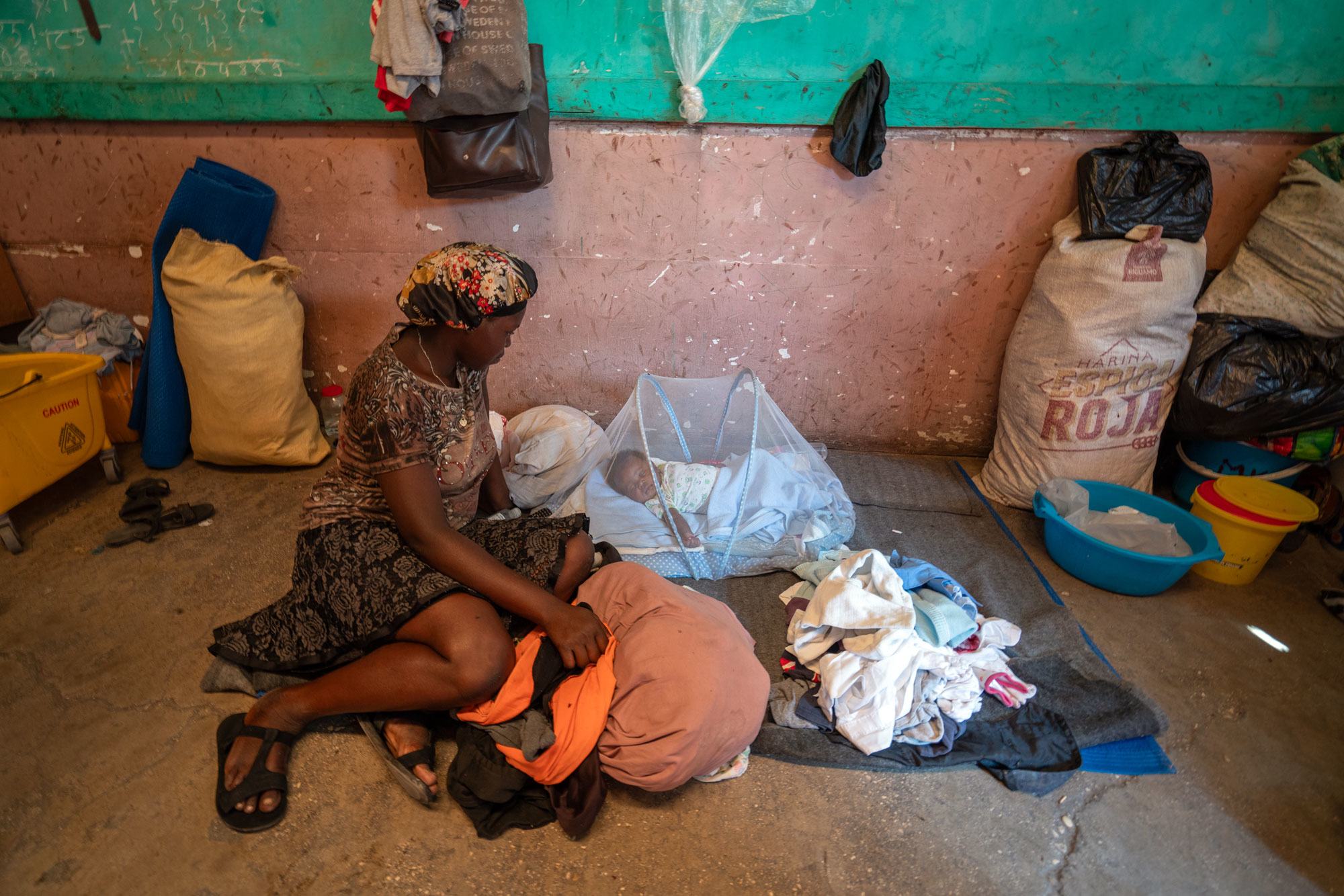 A displaced mother tends for her baby in a former school in downtown Port-au-Prince, Haiti.