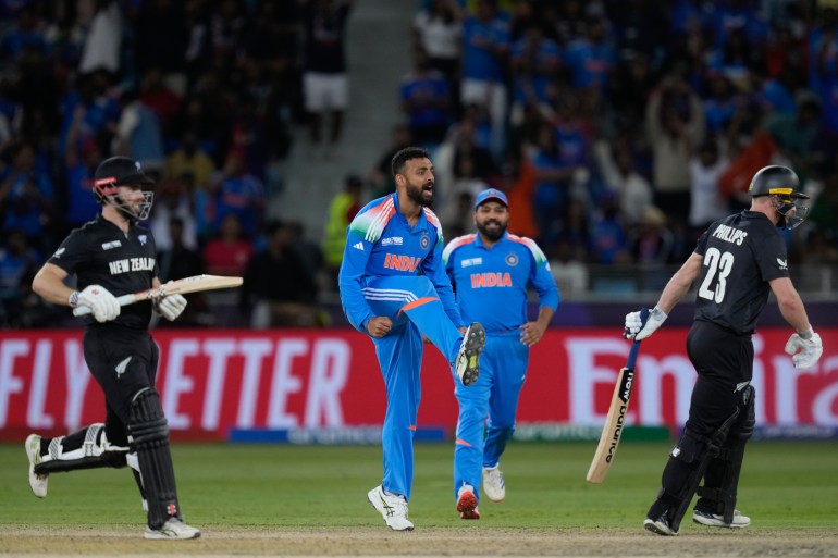 India's Varun Chakravarthy, centre, celebrate the wicket of New Zealand's Glenn Phillips , right, during the ICC Champions Trophy cricket match between India and New Zealand at Dubai International Cricket Stadium in Dubai, United Arab Emirates, Sunday, March 2, 2025. (AP Photo/Altaf Qadri )