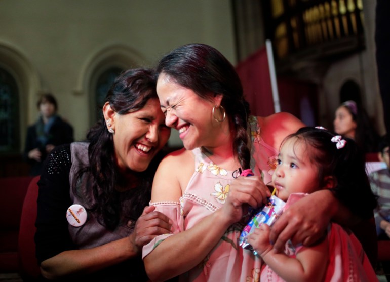 While holding her one-year-old daughter Camila Sanchez, Aura Hernandez, center, laughs with Jeanette Vizguerra 