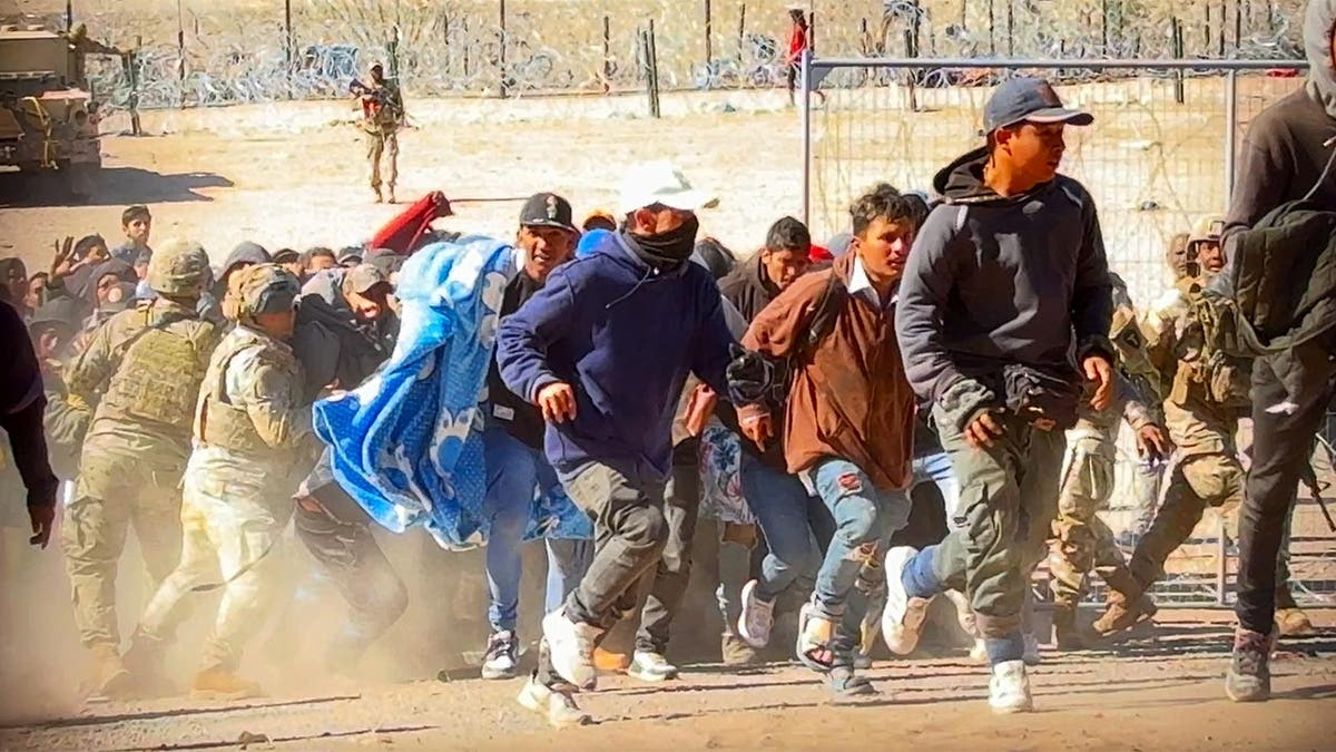 Migrants storming border gate